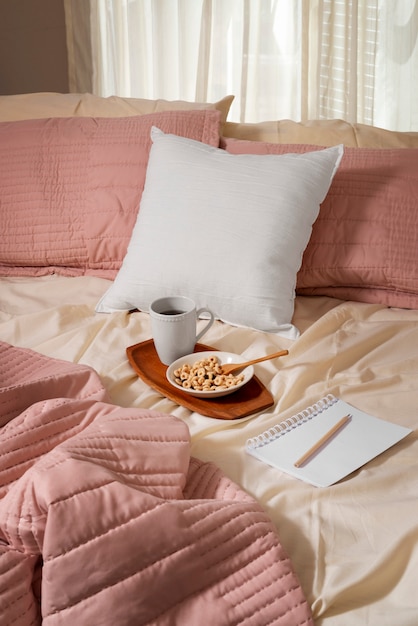 Free Photo high angle cozy bed arrangement with coffee cup