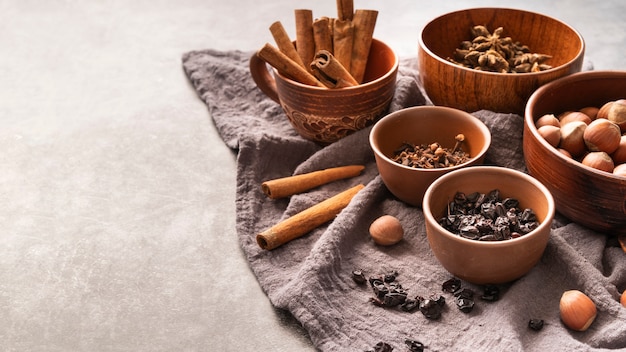 Free photo high angle decoration with cinnamon sticks and hazelnuts in bowls