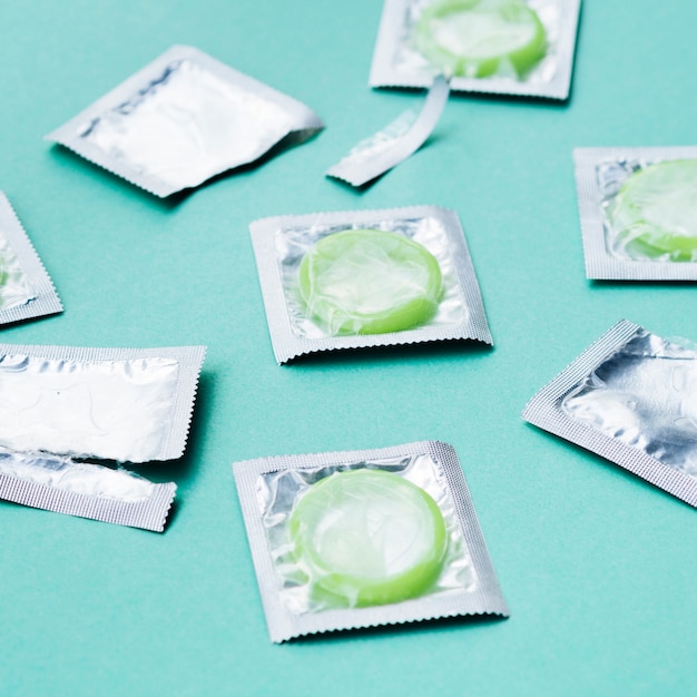 Free photo high angle green condoms on green background