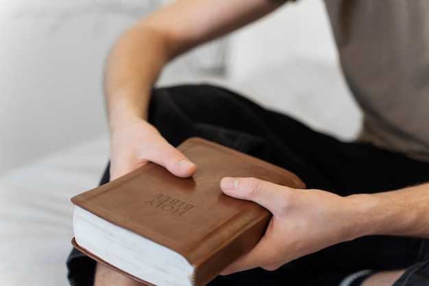 Free photo high angle hands holding holy bible