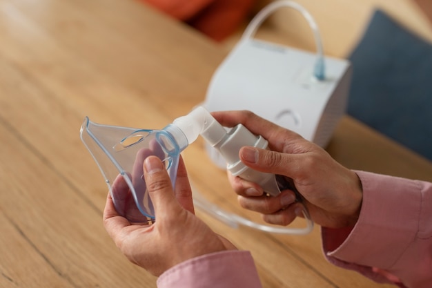 Free photo high angle man using nebulizer at home