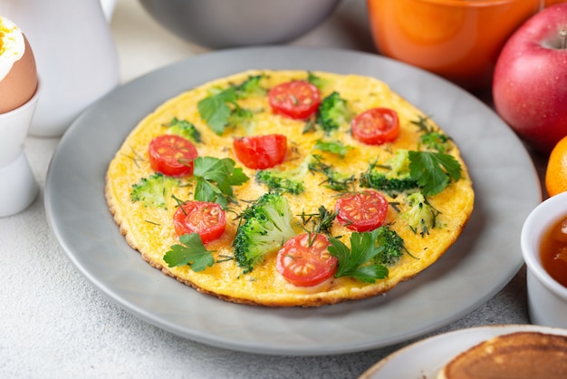 High angle of omelette in plate with tomatoes for breakfast