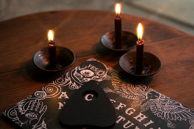 Free photo high angle ouija board and candles arrangement