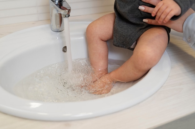 Free Photo high angle parent bathing kid in sink