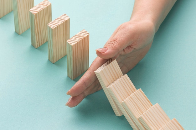 Free photo high angle person holding wooden pieces from falling