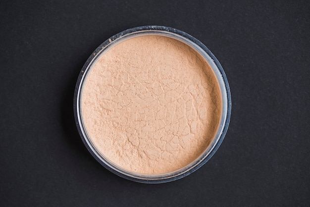 Free photo high angle view of face powder on black background