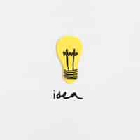 Free photo high angle view of light bulb with idea text on white backdrop