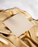 Free photo high angle white card on golden cloth