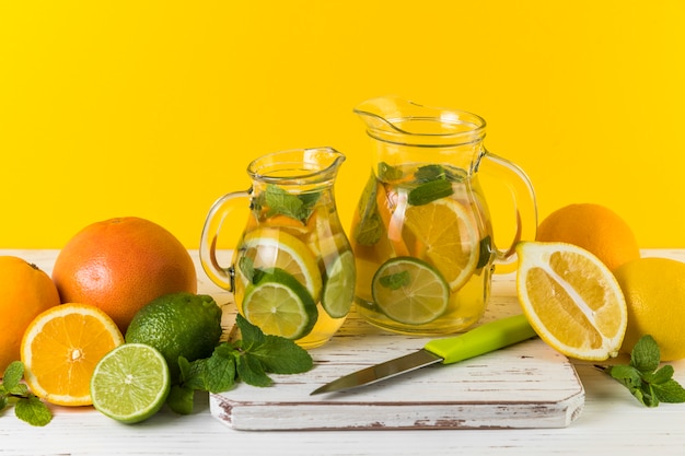 Homemade lemonade jugs with yellow background