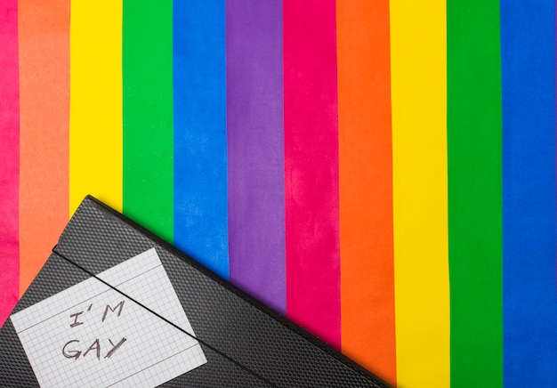 Free Photo i am gay words on paper against document case on lgbt flag