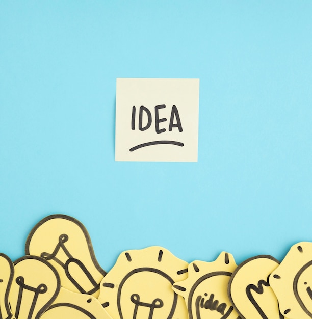 Free photo idea text on sticky note over the different yellow light bulbs on blue background