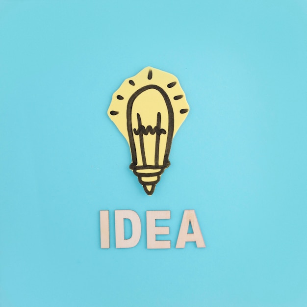 Free photo idea text with hand drawn light bulb on blue background