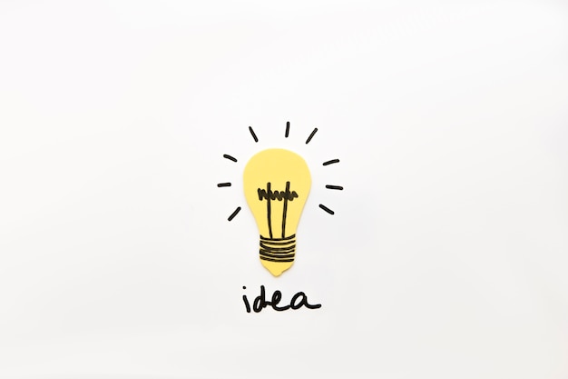 Free photo illuminated light bulb with idea word on black backdrop