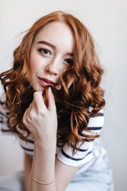 Free photo inspired girl wears elegant bracelet touching her red hair. spectacular ginger woman posing.