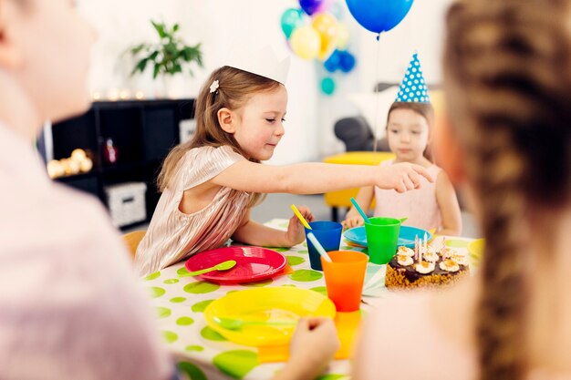 Kids in funny caps sitting at table