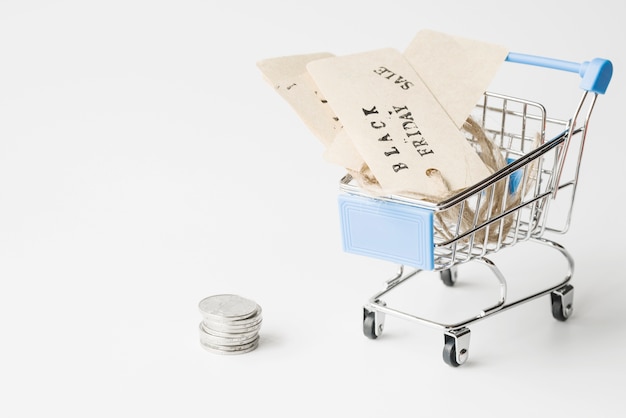 Free photo labels in shopping trolley near coins