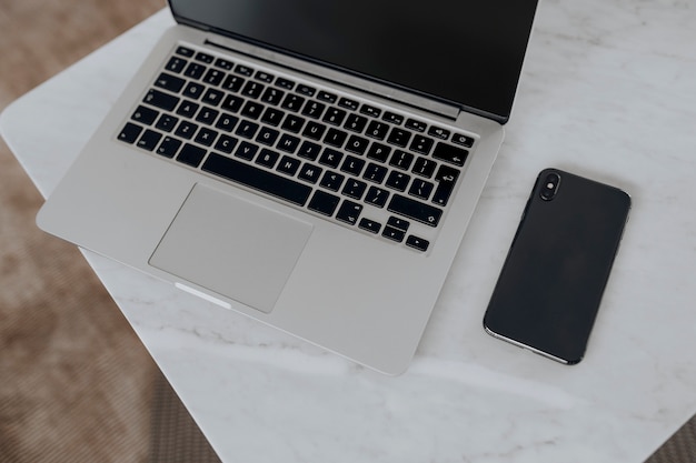 Free Photo laptop and a phone on a marble table