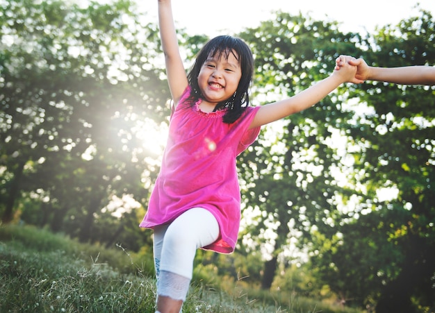 Free photo little asian girl playing in the park