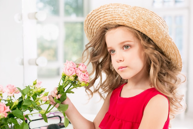 Free photo a little girl with red dress and cosmetics.