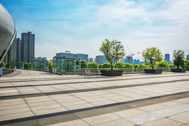 Free photo long empty footpath in modern city square with skyline.