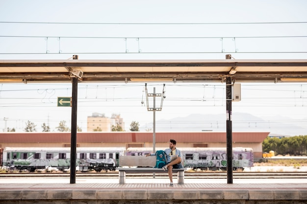 Free photo long shot traveler waiting for train