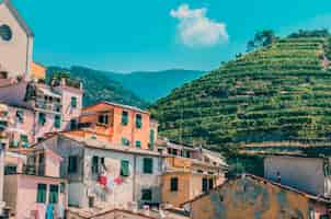 Foto gratuita lotto delle costruzioni vicino alle montagne coperte di erba verde sotto il cielo nuvoloso