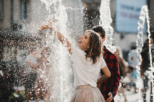 Free photo the lovely couple in love playing with fountain