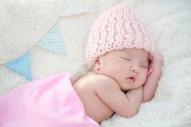 Free photo lovely newborn asian baby sleeping on furry blanket