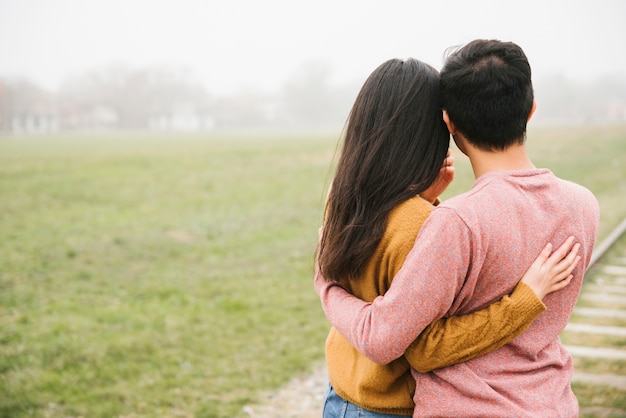 Free photo loving couple standing on rails and hugging