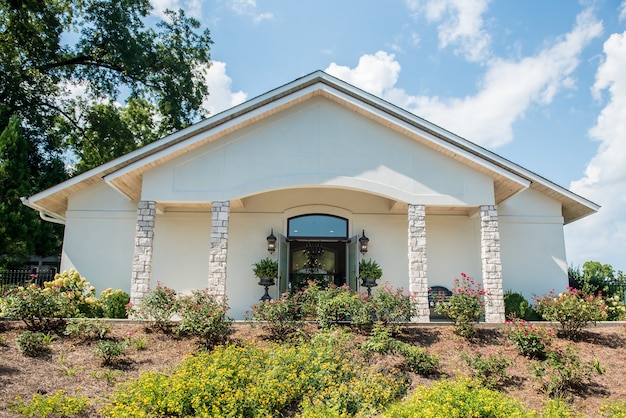 Free photo low angle shot of a white church with a beautiful flower garden