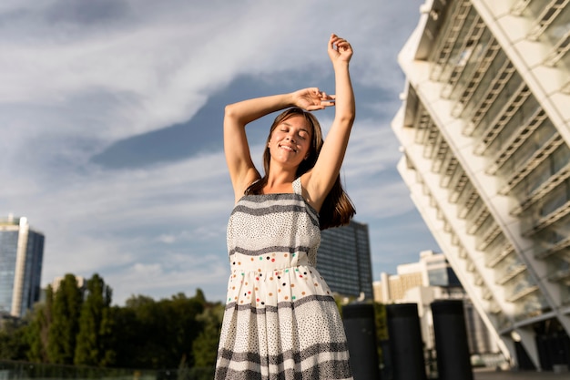 Free photo low angle young woman smiling while posing