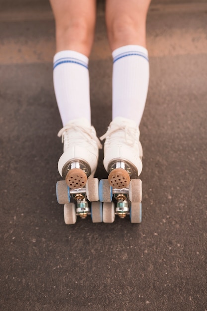 Free photo low section of woman's leg wearing roller skate on asphalt