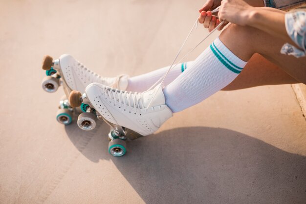 Low section of woman tying roller skate lace