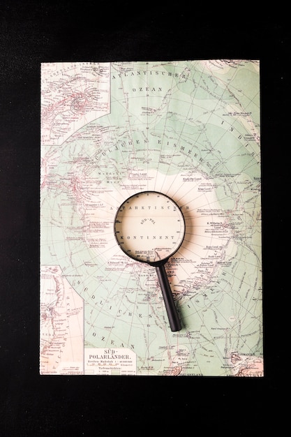 Free photo magnifying glass on atlas