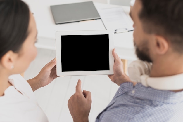 Free Photo male colleague showing tablet to female colleague