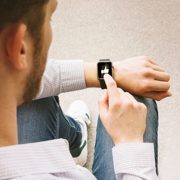 Free photo male finger taps like icon on smart watch