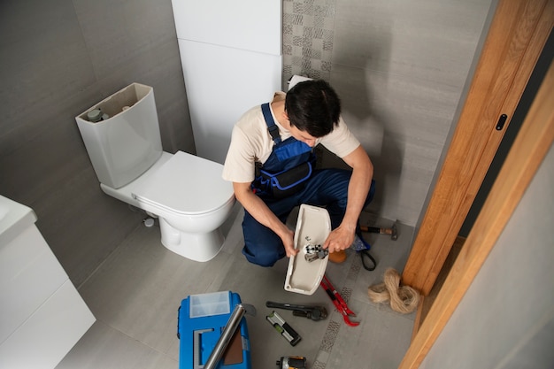 Free Photo male plumber working to fix problems at client's house