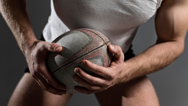 Foto gratuita giocatore di rugby maschio che tiene palla con entrambe le mani