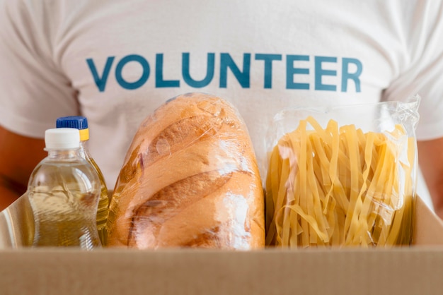 Free photo male volunteer holding box with provisions for charity