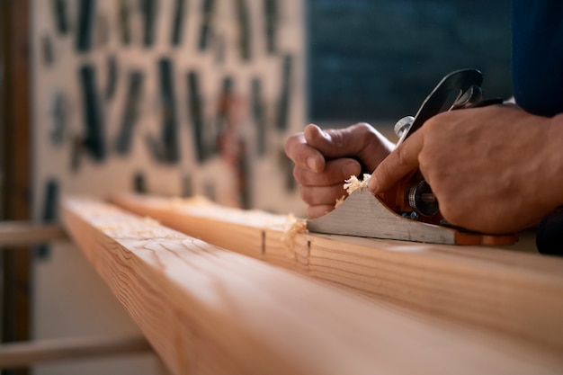 Free Photo male wood worker in his shop working with tools and equipment