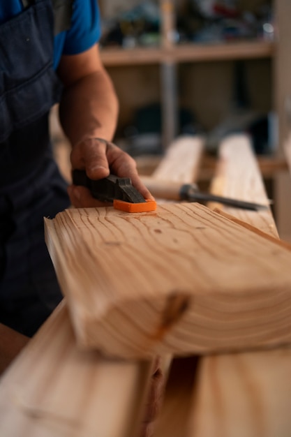 Free Photo male wood worker in his shop working with tools and equipment