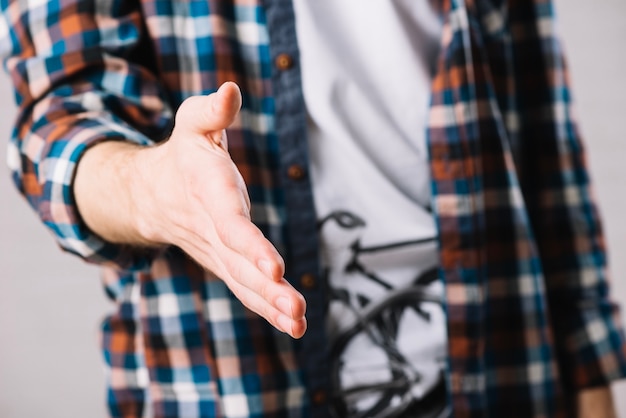 Foto gratuita uomo in camicia a scacchi che offre mano