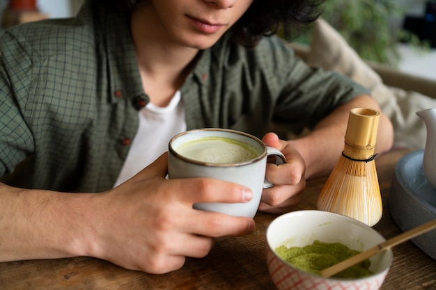 Free photo man enjoying a cup of matcha tea