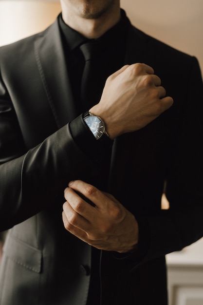 Man fastens a cufflink on his business suit