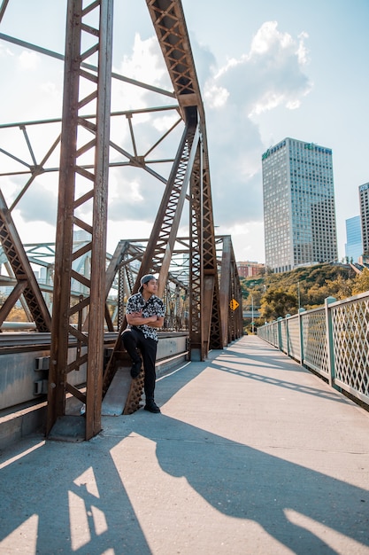 Free photo man standing beside bridge