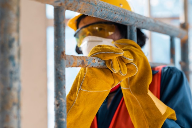 Free Photo man with safety equipment side view carrying ladder close up