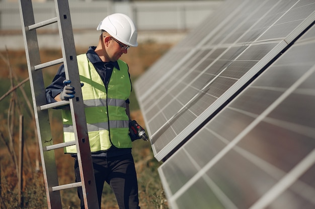 Free photo man with white helmet near a solar panel