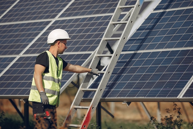 Free photo man with white helmet near a solar panel