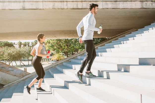 Free photo man and woman running steps working out