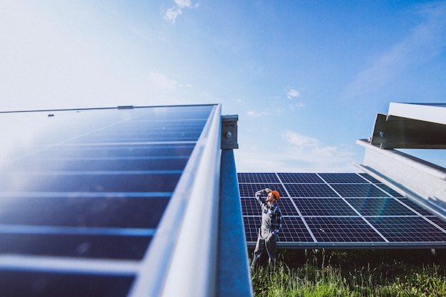 Free photo man worker in the firld by the solar panels